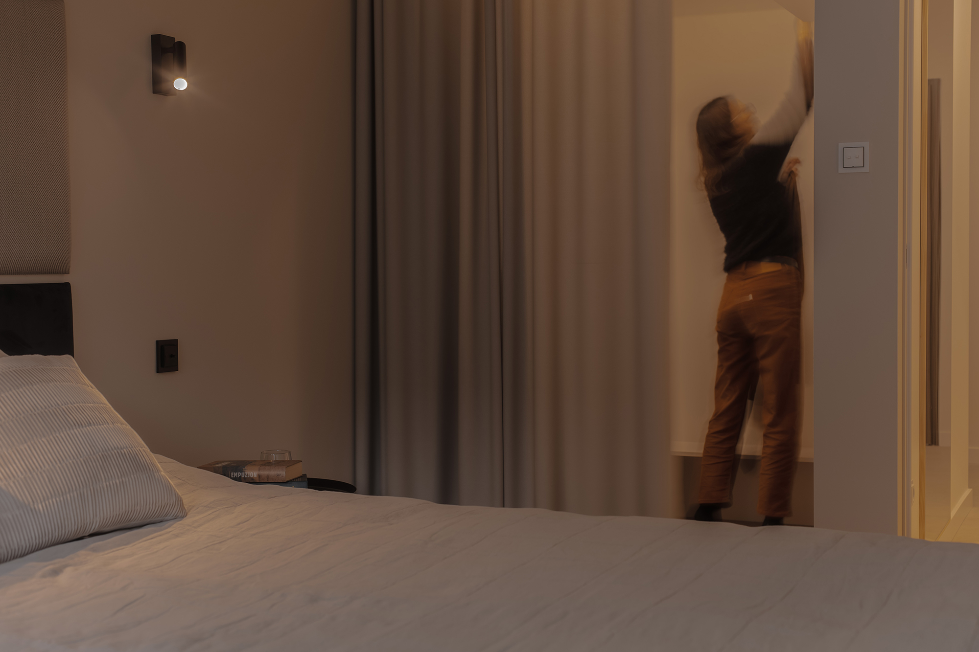 Garderoba oddzielona zasłonami, w lekki i miękki sposób wydziela jej przestrzeń w sypialni.